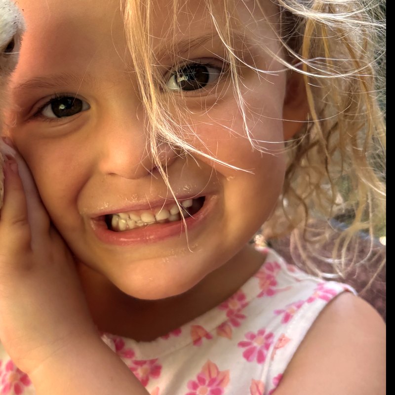 Gabby grinning with her hand on her cheek